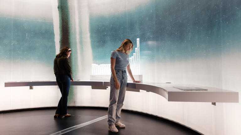 Photo of woman touching the Ice Core Interactive exhibit at the NMA's Great Southern Land exhibition 